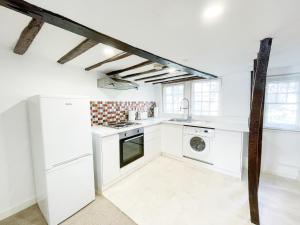 a white kitchen with a sink and a dishwasher at Chelmsford City - 17th Century Apartment in Chelmsford