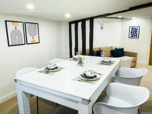 a dining room with a white table and white chairs at Chelmsford City - 17th Century Apartment in Chelmsford +8 photos