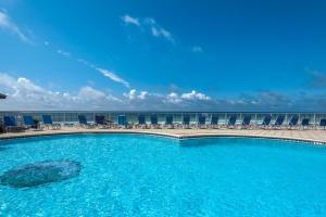 a large swimming pool with chairs and the ocean at Beach House 301D - Southern Magnolia in Destin