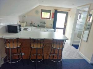 a kitchen with a counter and two bar stools at The Bedsit in Pembrokeshire