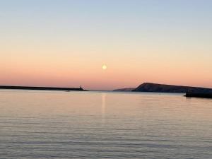 a sunset over a large body of water at The Bedsit in Pembrokeshire +3 photos