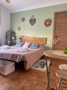 una camera con letto con testiera in legno e tavolo di Douce pause a Darnius