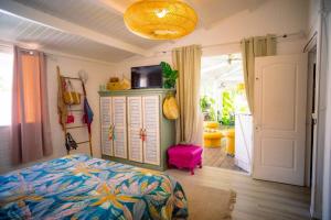 a bedroom with a bed and a television on top at Villa Le Ropert'Zen in Saint-François