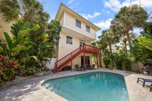 a house with a swimming pool in front of a house at Island Sun in Siesta Key