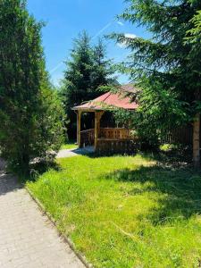 a gazebo with a red roof in the grass at Queen Apartment city Center in Mediaş