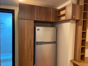 a stainless steel refrigerator in a kitchen with wooden cabinets at شاليهات اهرامات ابراج بورتو السخنه in Ain Sokhna