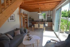 ein Wohnzimmer mit einer blauen Couch und einer Küche in der Unterkunft Roches Blanches 3 in Saint-Lunaire