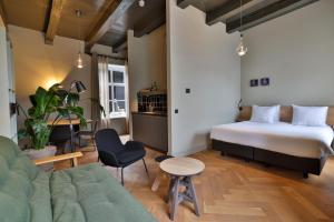a hotel room with a bed and a couch at Hotel Abdij Dokkum in Dokkum