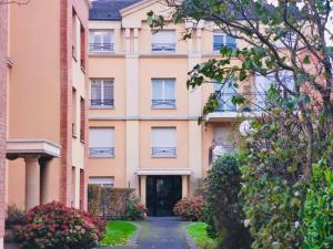 an apartment building with a driveway and flowers at Valenspot in Valenciennes