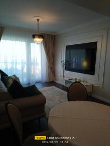 a living room with a couch and a flat screen tv at Avangarde de Lux Apartment in Seleuş