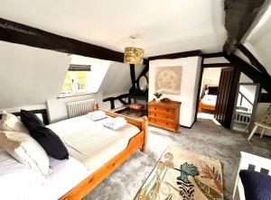une chambre avec un lit et un miroir dans l'établissement Stylish Tudor Cottage & Hot Tub, à Coombe Hill