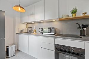 a kitchen with white cabinets and a microwave at 3 Zimmer EG Wohnung direkt am Kurpark in Bad Aibling +7 photos