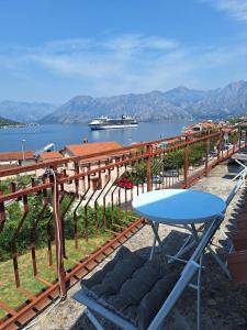 a table on a balcony with a cruise ship in the water at Dobrota Comfort in Kotor