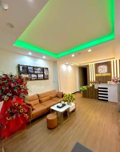 a living room with a couch and a table with flowers at ROSE HOSTEL DALAT in Da Lat