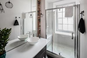un bagno bianco con 2 lavandini e una doccia di GA Apartments a Cracovia