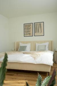 a bedroom with a bed with two pictures on the wall at NH 6 Interlaken-Luzern I Lake I Mountain I connect in Sachseln