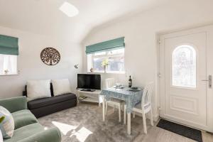 a living room with a couch and a table at Ty Cwtch in Nottage