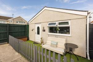 a backyard with a fence and a chair and a table at Ty Cwtch in Nottage