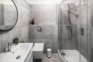 un bagno con doccia, WC e lavandino di GA Apartments a Cracovia