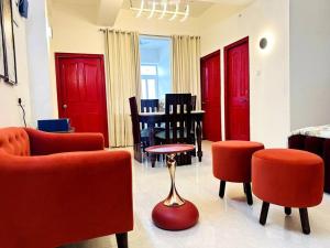a living room with red furniture and red chairs at Raktambar in Shivāpur