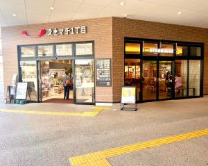 OrioゲストハウスＥn プレザント203的商店前,外面的人站在