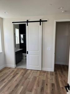 a room with a white door and a wooden floor at Cozy Retreat facing Western Park in Tracy