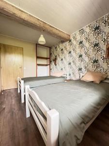 a bedroom with two beds and a wall with flowers at Gîte familial 10 pers jardin et piscine in Saint-Amour +38 photos