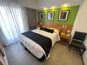 a bedroom with a large bed and a chair at Sarmiento Palace Hotel in Buenos Aires