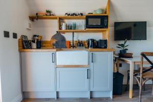 - une cuisine avec un comptoir, un four micro-ondes et une table dans l'établissement NEW The Paddocks Pod Selside - Thorn, à Lake District National Park 7 autres photos