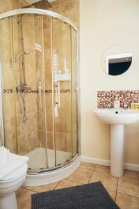 ein Badezimmer mit Dusche, Toilette und Waschbecken in der Unterkunft Barroon Castle Apartments - Next to East Midlands Airport with Free Parking in Castle Donington + 77 Fotos