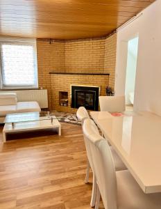 un soggiorno con tavolo, sedie e camino di Messe Apartment in Laatzen mit kostenlosen Parkplätz ad Hannover