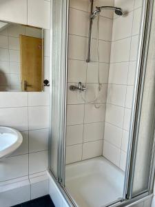 una doccia con una porta in vetro accanto a un lavandino di Messe Apartment in Laatzen mit kostenlosen Parkplätz ad Hannover