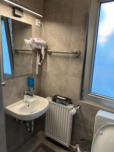 a bathroom with a sink and a toilet and a window at Hotel Elbe Street 34 in Frankfurt/Main