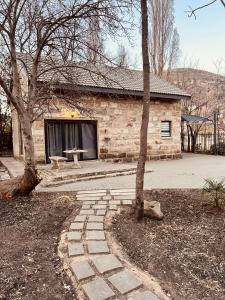 una casa in pietra con un sentiero in pietra in un cortile di Walnut Cottage a Clarens