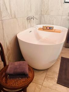 bagno con vasca bianca e sgabello. di Walnut Cottage a Clarens Altre 36 foto
