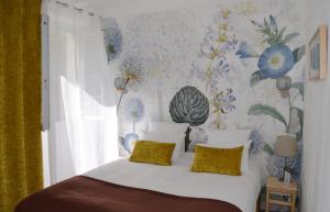 a bedroom with a bed with a floral wallpaper at Hôtel du Parc - Bastide provençale in Draguignan