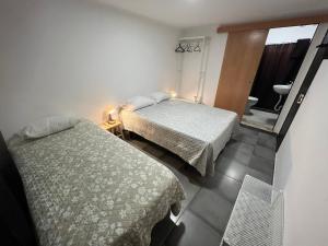 a bedroom with two beds and a bathroom with a window at ESTANQUEIRA GUEST HOUSE in Sines