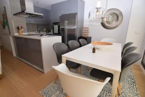 a kitchen with a white dining table and chairs at Dream Gardens 2 in Mijas Costa