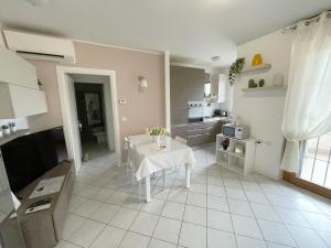 a kitchen with a white table and a white tiled floor at Torakiki's Home Linate Airport M2 Lambrate in Milan