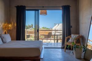 a bedroom with a bed and a view of a balcony at Baja Temple in Todos Santos