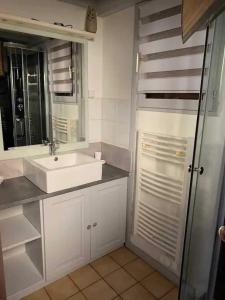 Un baño blanco con lavabo y espejo. en Chalet paisible et familial, en Gujan-Mestras