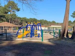 Un patio de juegos azul y amarillo en un parque en Chalet paisible et familial, en Gujan-Mestras