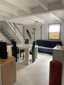 Una sala de estar con una mesa y sillas y un sofá. en Chalet paisible et familial, en Gujan-Mestras