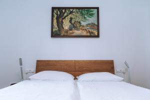 two beds in a bedroom with a painting on the wall at Dorfwirt Irschen in Irschen