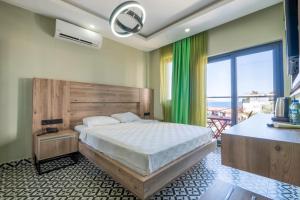 a bedroom with a bed and a large window at Zeytin HOTEL in Kaş