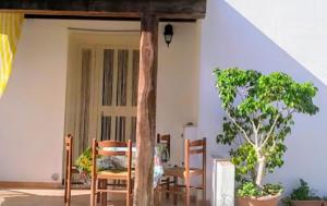 una habitación con 2 sillas y una puerta con un árbol en Villaloddo 3 Marina di Tertenia cap 08047 dietro Ristorante La Grotta, en Tertenìa