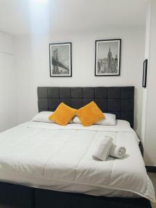 a large bed with two orange pillows on it at El Rodadero Hermoso Apartamento a 50m de la playa ven descansa o trabajar in Gaira +93 photos