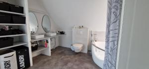 a bathroom with a sink and a toilet and two mirrors at Fare-Kermenezy maison avec piscine chauffée in Locmaria-Grand-Champ