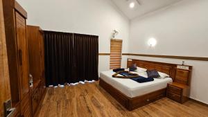 a bedroom with a bed and a black curtain at Casta Wild Resort in Batheri