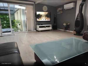 a living room with a tv and a glass table at Maison loft, jacuzzi in Livry-Gargan